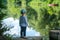 a little boy stands thoughtfully on the Bank of a beautiful river