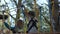 Little boy steps on shaking wooden islands in an adventure park