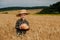 Little boy in the straw hat and shirt he held out his handing with bread in ripe grain. concept poverty, crisis, famine