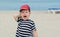 Little boy in a striped T-shirt whimsical cries against the sea.