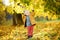 Little boy during stroll in the forest at sunny autumn day