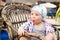 A little boy with a strong surprise on his face sitting in a wicker chair