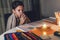 Little boy studying in low light with a burning candle.