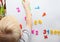 A little boy is studying the magnetic numbers on the fridge. Preschooler training