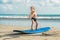 Little boy surfing on tropical beach. Child on surf board on ocean wave. Active water sports for kids. Kid swimming with