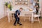 Little boy sweeping the floor. Pretty boy cleaning the kitchen w