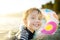 Little boy swimming with colorful floating ring in sea on sunny summer day. Cute child playing in clean water. Family and kids