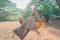 Little Boy swinging in a camping ground swing  freely, with sun and wood in the background