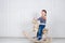 Little boy swinging on wooden horse. funny three-year-old boy in jeans and sweater on white background. Carefree childhood