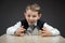 Little boy taking away house model and pile of coins