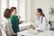 Little boy talking to family doctor during visit to hospital together with mother