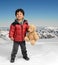 Little boy with teddy bear in the snow