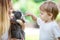 Little boy touching pet rabbit\'s nose while