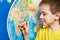 Little boy with toy giraffe shows Africa on world map