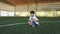 Little boy is training in indoor soccer field