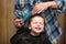 A little boy is trimmed in the hairdresser`s bright emotions on