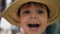 Little boy trying on a hat in a store and smiling. Kids shopping