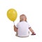 A little boy turned back with a big yellow balloon. Cute child paying a toy car isolated on a white background.