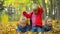 A little boy and two girls play in the autumn Park with yellow leaves lying on the ground