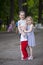 Little boy and two older cousins, meeting in the summer park