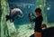 Little boy using a phone taking a photo of arapaima gigas, also known as pirarucu living in Amazon River in the underwater huge