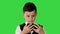 Little boy in waistcoat watching something on his phone and rounding his eyes in shock on a Green Screen, Chroma Key.