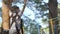 Little boy walks on a rope bridge in an adventure park - side view