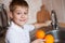 Little boy is washing fruit in the kitchen