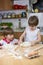 Little Boy Watching His Twin Brother While Kneading Dough For Pizza on the Kitchen Table