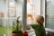 Little boy watching the rain outside at opened window and taking photo. Bad weather - wind and downpour. Inquisitive child explore