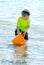 Little boy in water with orange bucket