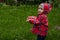 Little boy in a waterproof jacket in tractors catch the rain. Child having fun outdoors in summer shower