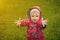 Little boy in a waterproof jacket in tractors catch the rain. Child having fun outdoors in summer shower