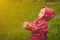 Little boy in a waterproof jacket in tractors catch the rain. Child having fun outdoors in summer shower