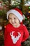 Little boy wearing Santa hat ready for celebrate Christmas. Cute child decorating the Christmas tree with glass toy