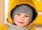 Little boy wearing scarf and hood smiling in winter snow