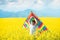 Little boy in white shirt running with kite in the booming yellow field