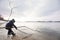 Little boy in winter cloths playing with tree stick and ice on the beach. Nature park and outdoors. Playing child at the river