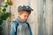 Little boy on a wooden wall background. Humble shy child. Melancholy. Romance. Melancholic mood.