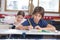 Little Boy Writing Notes With Classmate In