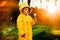 Little boy in a yellow jacket at sunset in the forest blowing a dandelion. Nature care concept.  Take care of the environment. Act