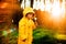 Little boy in a yellow jacket at sunset in the forest blowing a dandelion. Nature care concept.  Take care of the environment. Act