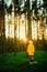 Little boy in a yellow jacket at sunset in the forest. Nature care concept.  Take care of the environment. Action against deforest