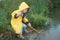 Little boy in yellow raincoat by stream