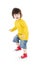 Little boy in yellow shirt stands and warily looks away