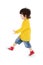 Little boy in yellow shirt walks isolated