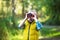 The little boy young researcher looks up and exploring with binoculars environment