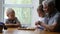 Little boys children play checkers with grandfather at home, senior positive man