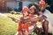 Little boys in firemen costumes. African American father playing with his children. Little boys playing in the garden