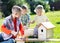 Little boys friends making wooden nest box in summer green park